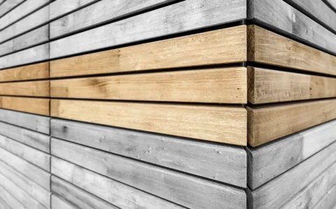 Eckansicht einer Holzfassade mit horizontalen Leisten.