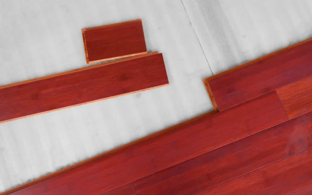 Aufsicht auf rote Holzfußboden Dielen, teils eingeklickt, auf Dämmunterlage.