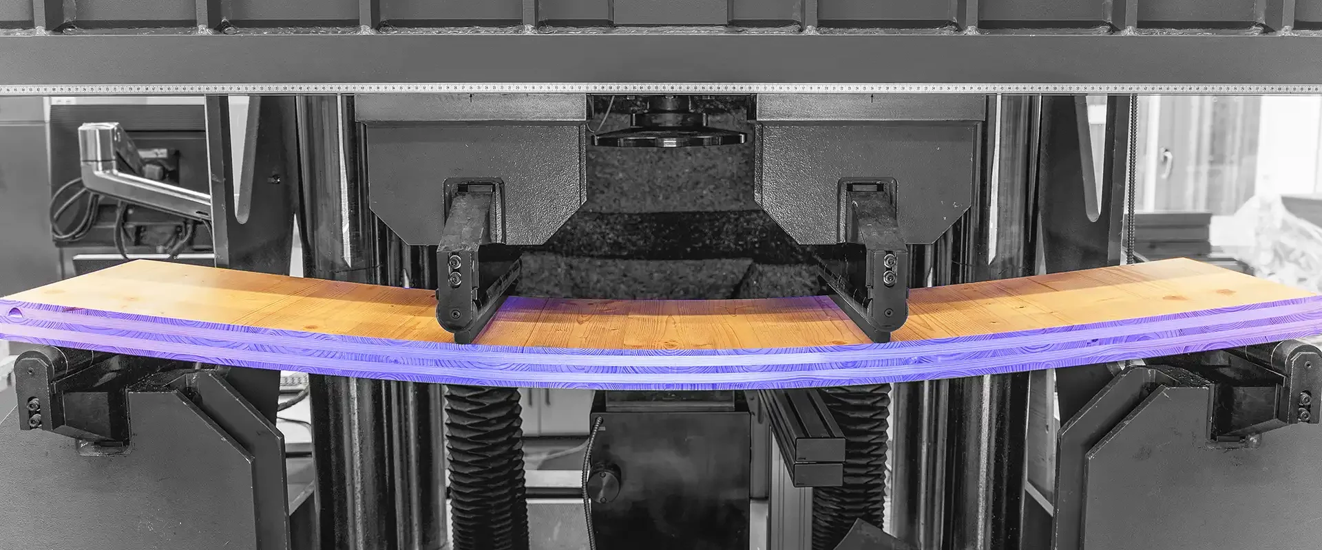 Große Prüfmaschine biegt einen Brettschichtholz Balken im Vierpunkt Biegeversuch.