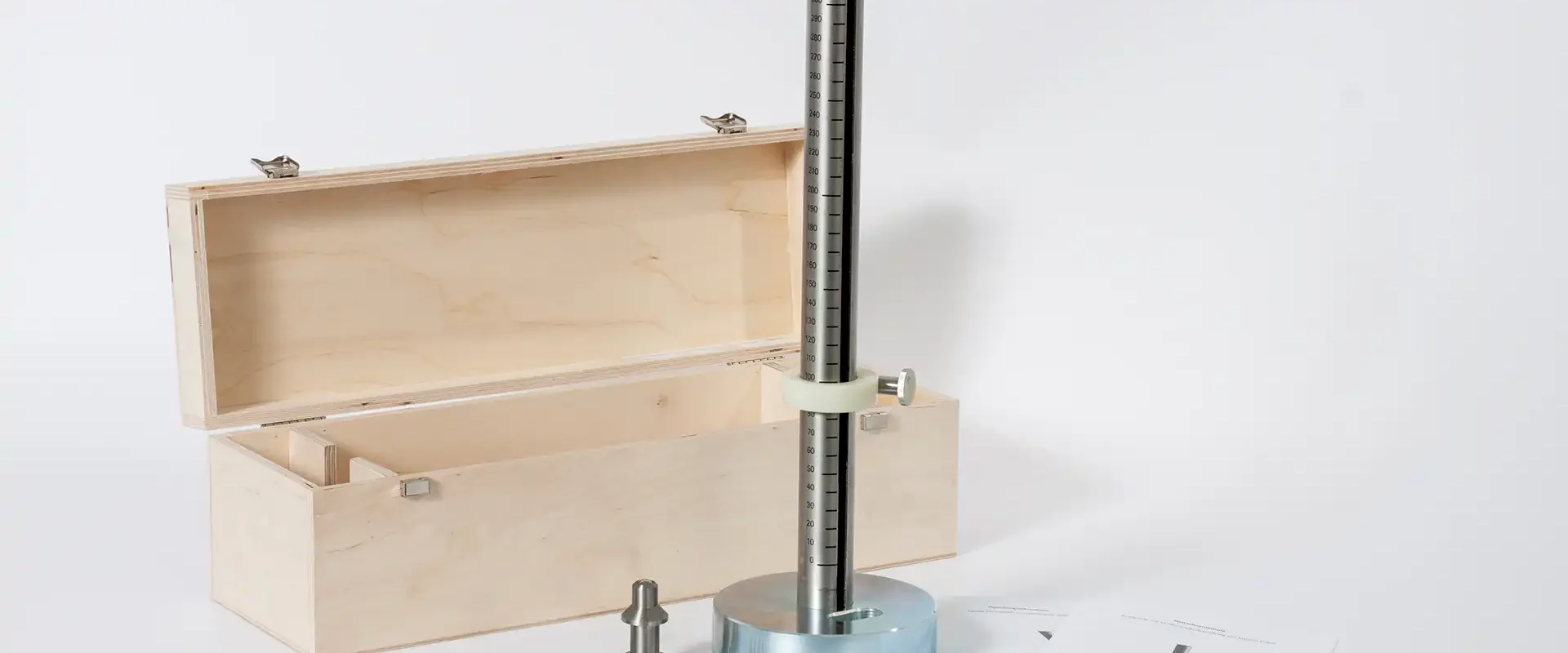 Prüfgerät für den Kleine-Kugel-Falltest: massiver runder Fuß mit vertikaler, skalierten Fallstange und Klemmring