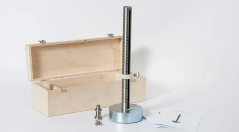 Small-ball impact/drop tester: heavy round base with a vertical graduated drop rod and clamp