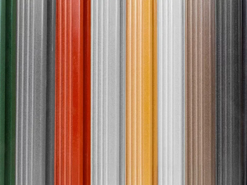 Nahaufnahme gerillter WPC Profile in verschiedenen Farben nebeneinander.