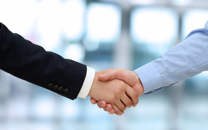 Handschlag zwischen zwei Geschäftspartnern als Zeichen von Zusammenarbeit und Vertrauen